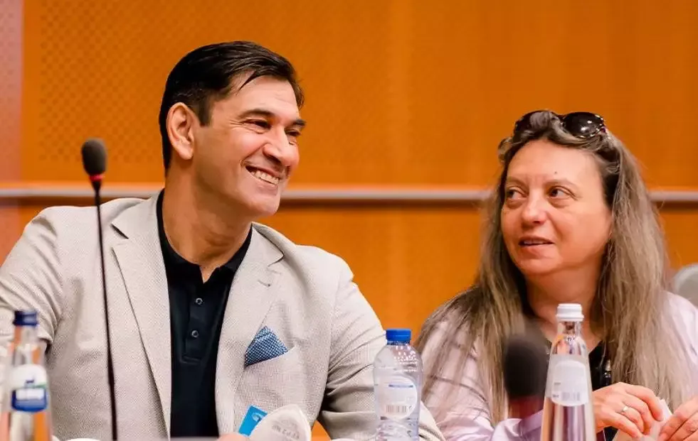 Two people smiling during a conference discussion.