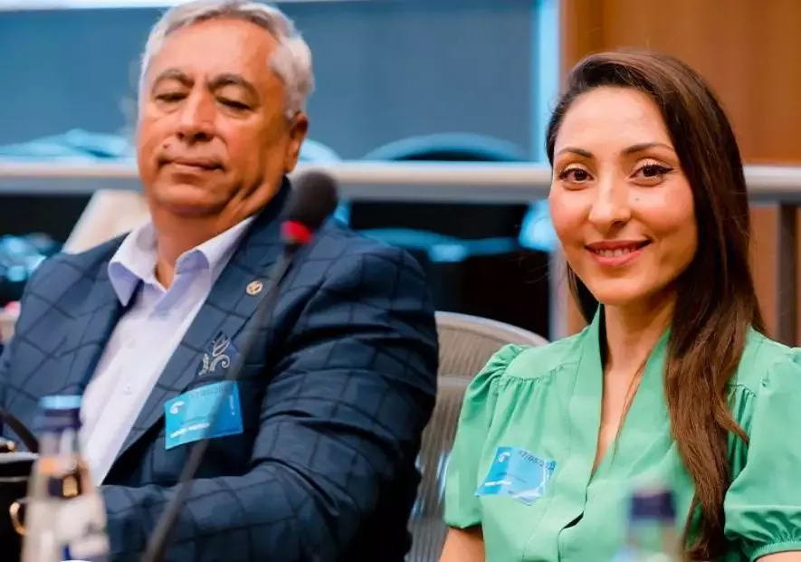 Two people sitting at a conference table.