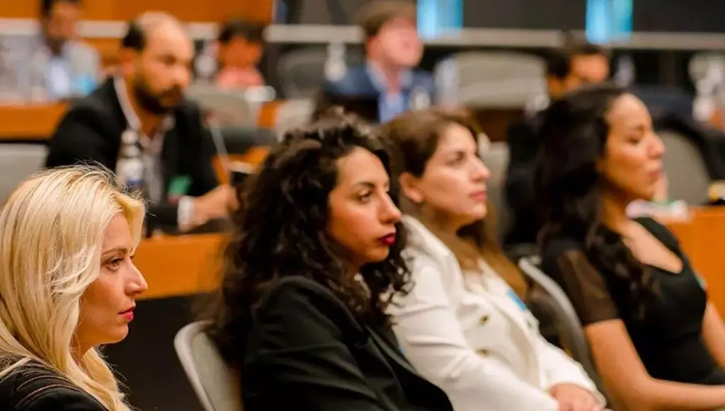 Diverse group of professionals attentively watching presentation.